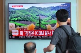 People watch a TV report showing what was said to be the launch of a North Korea's ICBM, aired by North Korea's KRT, at Seoul Train Station in Seoul, South Korea, July 4, 2017.