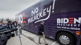 FILE - Democratic presidential candidate and former Vice President Joe Biden boards his No Malarkey bus following a campaign stop in Council Bluffs, Iowa on Nov. 30, 2019. (AP Photo/Nati Harnik)