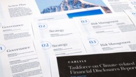 FILE - Pages from a Carlyle Group 2021 report on its financial risk from greenhouse gas emissions are photographed Tuesday, Sept. 20, 2022. Documents and contracts often contain what is called boilerplate language. (AP Photo/Jon Elswick)