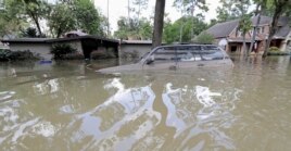 FILE - A car is submerged in floodwaters in the aftermath of Hurricane Harvey near the Addicks and Barker Reservoirs in Houston, Sept. 4, 2017.