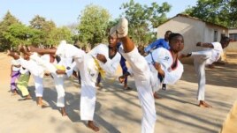Natsiraishe Maritsa, second right, goes through taekwondo kicking drills during a practice session with young boys and girls in the Epworth settlement about 15 km southeast of the capital Harare, Saturday Nov. 7, 2020.