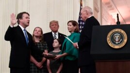 Retired Justice Anthony Kennedy, right, ceremonially swears-in Supreme Court Justice Brett Kavanaugh, as President Donald Trump looks on, in the East Room of the White House in Washington, Monday, Oct. 8, 2018. Ashley Kavanaugh holds the Bible and daughters Margaret, left, and Liza, look on. (AP Photo/Susan Walsh)