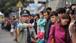 FILE - A security guard blows a whistle at a bus stop outside a railway station Hefei, Anhui province during a busy time, Oct. 7, 2013. (Reuters photo)