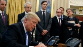 White House chief strategist Steve Bannon (far right) is among the top policy advisers present as President Donald Trump signs an executive order in the Oval Office, Monday, Jan. 23, 2017.