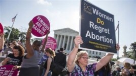 People on both sides on the abortion issue gather outside the U.S. Supreme Court on Monday