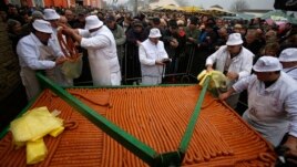 FILE - Cooks sell a 2,031 meter-long sausage made for the 31st annual Sausage Festival in the village of Turija, about 100 kilometers (60 miles) northwest of Belgrade, Serbia, Feb. 28, 2015. (AP Photo/Darko Vojinovic)