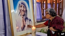 An Indian Catholic woman offers prayers as she touches a portrait of Mother Teresa on her 17th death anniversary at the Missionaries of Charity in Kolkata, in 2014. Mother Teresa is to be named a saint by the Roman Catholic Church.