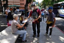 Juan Pablo Lares distributes free copies of a newspaper 