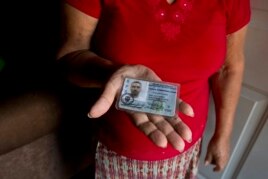 In this Nov. 3, 2018 photo, Haydee Posadas shows the driver's license her son Wilmer Gerardo Nunez was carrying when he was blindfolded and shot dead on his journey north, at her home in Ciudad Planeta neighborhood of San Pedro Sula, Honduras.