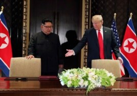 FILE PHOTO: U.S. President Donald Trump and North Korea's leader Kim Jong Un (L) arrive to sign a document to acknowledge the progress of the talks.