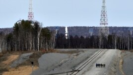 A Russian Soyuz rocket, center in the background, carrying satellites stands on the launch pad at the new Vostochny Cosmodrome near Uglegorsk, the city in eastern Siberia in the Amur region, Russia, April 27, 2016.