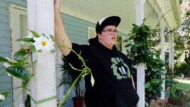 Gavin Grimm leans on a post on his front porch during an interview at his home in Gloucester, Va. Grimm is a transgender student whose demand to use the boys' restrooms has divided the community and prompted a lawsuit.