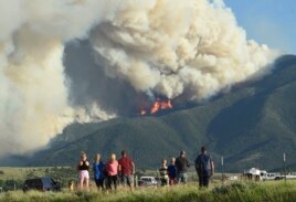 Residents watch as flames from the Robertson Draw fire burn above Red Lodge, Mont., Tuesday evening, June 15, 2021.(Larry Mayer/The Billings Gazette via AP)