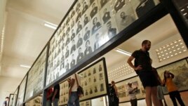 FILE - Tourists view portraits of victims executed by the Khmer Rouge regime at the Tuol Sleng Genocide Museum, formerly a notorious Khmer Rouge prison, in Phnom Penh, Cambodia, April 9, 2015.