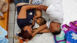 Honduran family Nolvia Luja, left, Willian Bonilla, and their son Wilmer Bonilla, who attended the annual Migrants Stations of the Cross caravan for migrants' rights, rest at a shelter in Tlaquepaque, Jalisco state, Mexico, April 18, 2018.