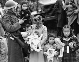 FILE - In this March 30, 1942 file photo, Cpl. George Bushy, left, a member of the military guard which supervised the departure of 237 Japanese people for California