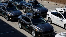 A group of self-driving Uber vehicles position themselves to take journalists on rides during a media preview at Uber's Advanced Technologies Center in Pittsburgh, Pennsylvania, Sept. 12, 2016.