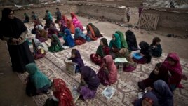 FILE - In this Tuesday, Feb. 4, 2014, photo, Afghan refugee children attend class at a makeshift school set up in a mosque on the outskirts of Islamabad, Pakistan. (AP Photo/Muhammed Muheisen)