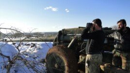 A Free Syrian Army fighter uses binoculars near the Menagh military airport, in Aleppo's countryside, Syria, January 10, 2013.