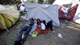 A Venezuelan refugee family rests outside a makeshift camp before going out to find any kind of work in Quito, Ecuador, August 9, 2018.