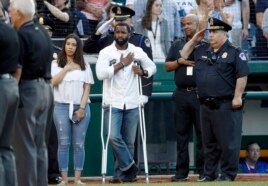 Injured Capitol Hill Police officer David Bailey, center, holds his hand over his heart during Congressional baseball game.