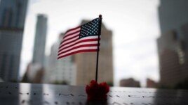 An American flag and red rose stand in the names of those lost at the edge of the south reflecting pool of the 9/11 Memorial & Museum ahead of the 20th anniversary of the 9/11 attacks in lower Manhattan in New York City, New York, U.S., September 8, 2021. (REUTERS/Mike Segar)