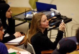 Gwyneth Glissmann of Boulder, Colorado, uses a special device to answer a question in the physics class of Professor Michael Dubson at the University of Colorado in Boulder, Colorado during his lecture.