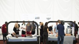 In this photo provided by the Washington Redskins defensive coordinator Greg Manusky, right, and cornerback Greg Stroman are fitted for custom Bedgear mattresses in Ashburn, Va., Sept. 24, 2018. (Garrett Campbell/The Washington Redskins via AP)