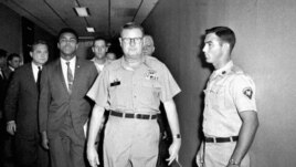 FILE - Heavyweight boxing champion Muhammad Ali is escorted from the Armed Forces Examining and Entrance Station in Houston by Lt. Col. J. Edwin McKee, after Ali refused Army induction, April 28, 1967. Ali died at age 74, June 3, 2016.