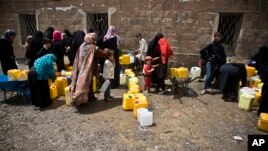 FILE - Women and children wait to fill buckets with water from a public tap amid an acute shortage of water, in Sana'a, Yemen, May 9, 2015. (AP Photo/Hani Mohammed)