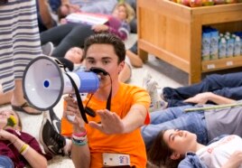 Marjorie Stoneman Douglas High School student David Hogg speaks as demonstrators lie on the floor at a Publix Supermarket in Coral Springs, Fla., May 25, 2018.