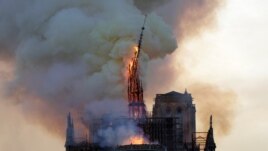 The steeple and spire of the landmark Notre-Dame Cathedral collapses as the cathedral is engulfed in flames in central Paris on April 15, 2019.