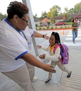 School secretary Demitra Cain, left, greets Tahja Hollerman, 5, for her first day of kindergarten at Codwell Elementary School, Sept. 11, 2017, in Houston.