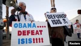 Raul Rodriguez Jr., left, of America First Latinos protests against the Islamic State group ahead of President Barack Obama's visit with the families of shooting victims in San Bernardino, Calif., Dec. 18, 2015. (REUTERS/Patrick T. Fallon)