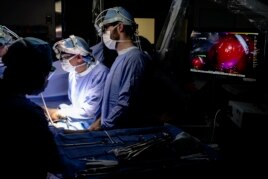 Dr. Sunil Singhal, second from right, directs a special camera to view a tumor in his patient made visible with a fluorescent dye, seen at monitor on right, at the Hospital of the University of Pennsylvania in Philadelphia, Tuesday, Jan. 23, 2018