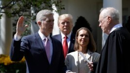 President Donald Trump watches as Supreme Court Justice Anthony Kennedy administers the judicial oath to Judge Neil Gorsuch during a re-enactment in the Rose Garden of the White House White House in Washington, April 10, 2017.