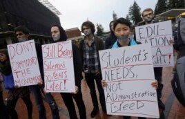 In this photo from 2014, students hold signs as they protest a series of tuition increases planned for the University of California