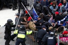 Pro-Trump protesters tear down a barricade as they clash with Capitol Police during a rally to contest the certification of the 2020 U.S. presidential election results by the U.S. Congress, at the U.S. Capitol Building in Washington, Jan. 6, 2021.