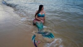 FILE - Lauren Metzler prepares for a swim at Manly Cove Beach in Sydney, Australia, Thursday, May 26, 2022. Mermaid does not have to worry about sink or swim. (AP Photo/Mark Baker)