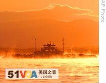 A ferryboat travels across Lake Champlain as the sun drops