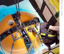 Researchers lowering the underwater robot into Lake Bonney