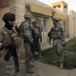 United States Army soldiers stand near an Iraqi police station in Hawija during a joint operation with Iraqi security forces Wednesday